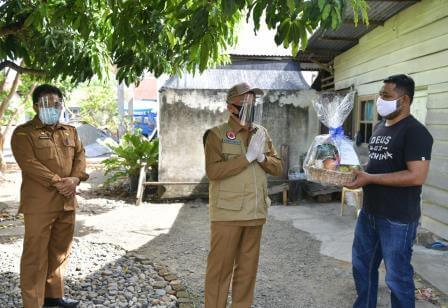 Sekda Aceh, Taqwallah, didampingi Karo Humas dan Protokol Setda Aceh, Muhammad Iswanto menyerahkan buah tangan kepada Maulan Risqan, petugas Balitbangkes Aceh di Gampong Ceurih, Ulee Kareng, Banda Aceh, Senin (10/8)