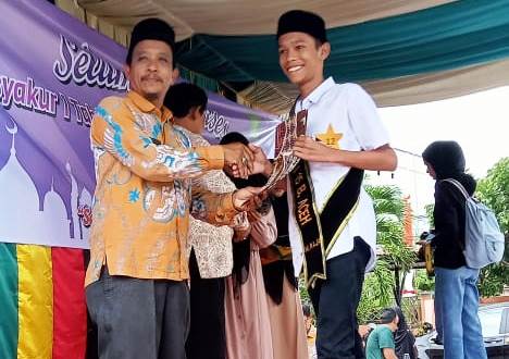 Kepala SMAN 15 Adidarma, Zulfikar SE MSi menyerahkan penghargaan kepada peserta tasyakuran tahfiz di halaman sekolah tersebut, Gampong Mulia, Kecamatan Kuta Alam, Banda Aceh, Selasa (30/5)