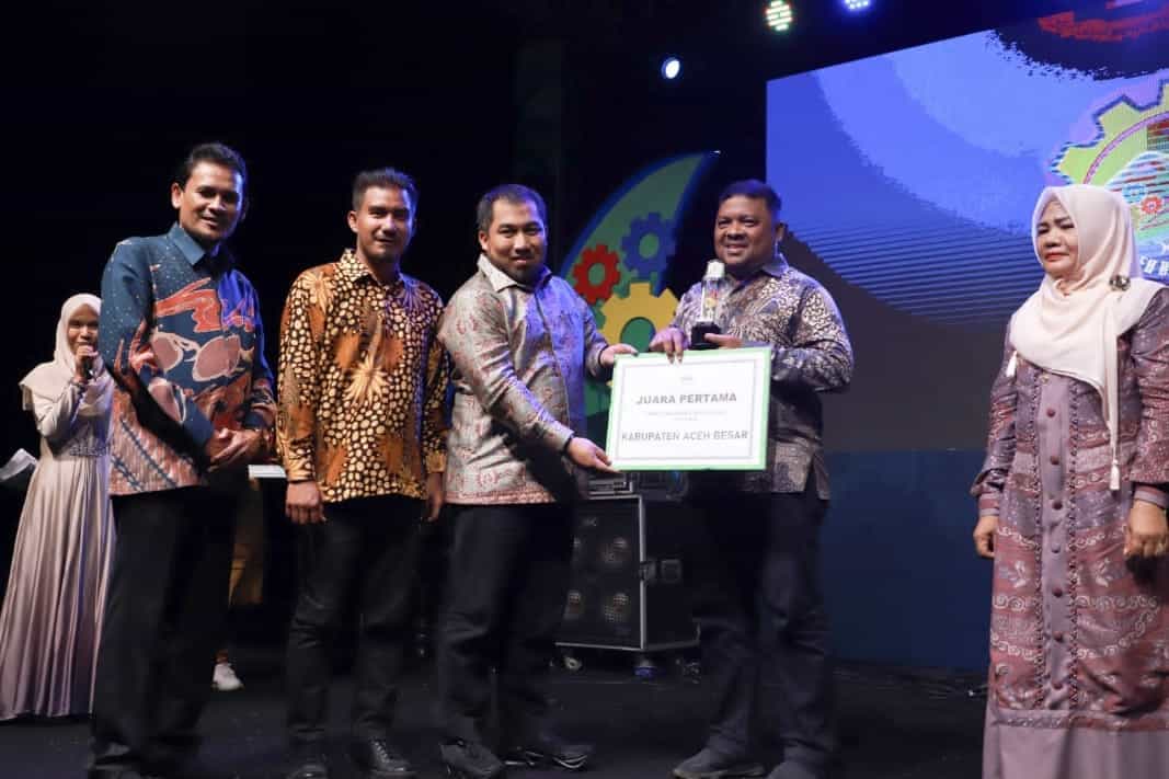 Pj Bupati Aceh Besar Muhammad Iswanto didampingi Kepala DPMG Aceh Zulkifli MSi menyerahkan hadiah kepada pemenang juara stand terbaik Gelar TTG XXlV Aceh di komplek JSC Kota Jantho, Jumat malam (2/6)