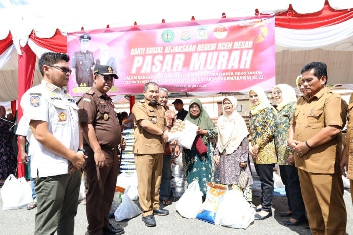 Pj Bupati Aceh Besar Muhammad Iswanto bersama Kajari Aceh Besar Basril G SH MH menyerahkan secara simbolis belanjaan warga di pasar murah yang digelar Pemkab Aceh Besar bekerja sama dengan Kejari setempat, di Kota Jantho Selasa (18/7)