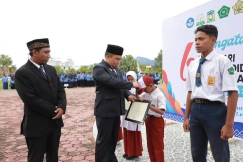 Pj Bupati Aceh Besar Muhammad Iswanto menyerahkan penghargaa kepada siswa peraih juara O2SN Aceh usai Upacara Hardikda ke-64 di halaman Kantor Bupati Aceh Besar, Senin (4/9)