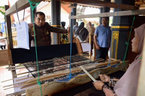 Pj Bupati Aceh Besar Muhammad Iswanto berbincang dengan pengrajin teunun tradisional yang berdiri tahun 1970 ditampilkan di Anjungan Aceh Besar PKA-8 Taman Sulthanah Safiatuddin, Banda Aceh, Ahad (5/11)