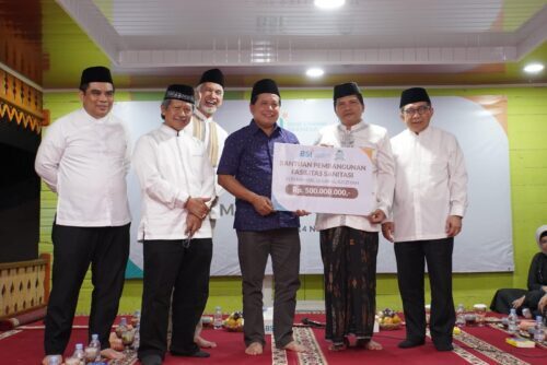 Dirut BSI Hery Gunardi menyerahkan bantuan kepada Pimpinan YLPI Dayah Mahyal Ulum Al-Aziziyah Tgk H Faisal Ali untuk pembangunan fasilitas sanitasi senilai Rp 500 juta di Dayah Mahyal Ulum Al Aziziyah, Aceh Besar, Selasa (14/11). (Foto: Dok. BSI)
