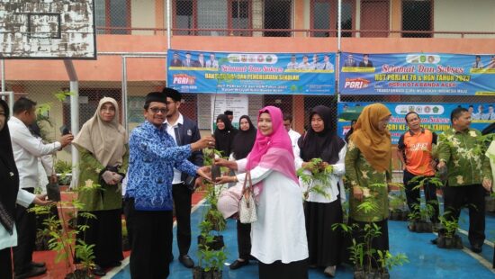 Ketua PGRI Banda Aceh Zulfikar SE MSi menyerahkan pohon kepada kepala sekolah dalam rangka memperingati HUT ke-78 PGRI dan HGN Tahun 2023, di Sekretariat PGRI Banda Aceh di SMAN 15 Adidarma Banda Aceh, Rabu (29/11)