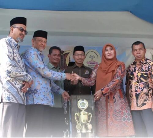 Kakankemenag Banda Aceh Salman Arifin menyerahan piala bergilir juara umum lomba MARSSAL 10 kepada Kepala MIN 6 Model Banda Aceh Hilmiyati SAg MA, Kamis (1/2)