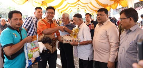Kajari Aceh Besar Basril G SH MH didampingi Sekda Aceh Besar Sulaimi menyerahkan secara simbolis belanjaan sembako kepada warga pada gelaran Pasar Murah Pemkab Aceh Besar kerja sama dengan Perum Bulog Aceh, Kejari Aceh Besar, di halaman Kejari Aceh Besar, Jantho, Jumat (1/3)