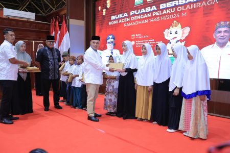 Ketua KONI Aceh Kamaruddin Abubakar atau Abu Abu Razak didampingi Pj Gubernur Aceh Bustami Hamzah menyerahkan santunan anak yatim pada acara buka puasa bersama KONI Aceh di Anjong Mon Mata, Komplek Pendopo Gubernur Aceh, Rabu (3/4)
