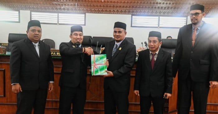 Pj Bupati Aceh Besar Muhammad Iswanto didampingi Ketua TAPD sekaligus Sekda Aceh Besar Sulaimi, menyerahkan Rancangan Qanun Pertanggungjawaban APBK Aceh Besar tahun 202 kepada Wakil Ketua DPRK Zulfikar Azis didampingi Wakil Ketua Gunawan, Senin (24/6). (Foto: For Infoaceh.net)