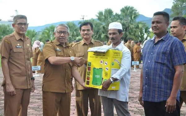 Asisten I Sekda Aceh Besar Farhan AP, menyerahkan handsprayer kepada petani, pada peringatan Hari Krida Pertanian 2024, usai pelaksanaan apel gabungan, di halaman Kantor Bupati Aceh Besar, Kota Jantho, Senin pagi (24/6/2024). Foto: For Infoaceh.net