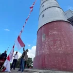 Kepala Badan Kesbangpol Aceh Dedy Yuswadi bersama Kabid Bina Ideologi, Wawasan Kebangsaan Dan Karakter Bangsa Munarwansyah mengibarkan Bendera Merah Putih di Mercusuar Willem's Torrent III, Pulo Breuh, Aceh Besar, Sabtu, 6 Juli 2024. Foto: Istimewa