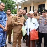 Pj Bupati Aceh Besar Muhammad Iswanto menyerahkan paket sembako secara simbolis pada pangan murah yang digelar Lanud SIM, Pemkab Aceh Besar dan Perum Bulog Kanwil Aceh di halaman Meunasah Gampong Lamreung, Kecamatan Darul Imarah, Aceh Besar, Senin (29/7/2024). (FOTO/MC ACEH BESAR)