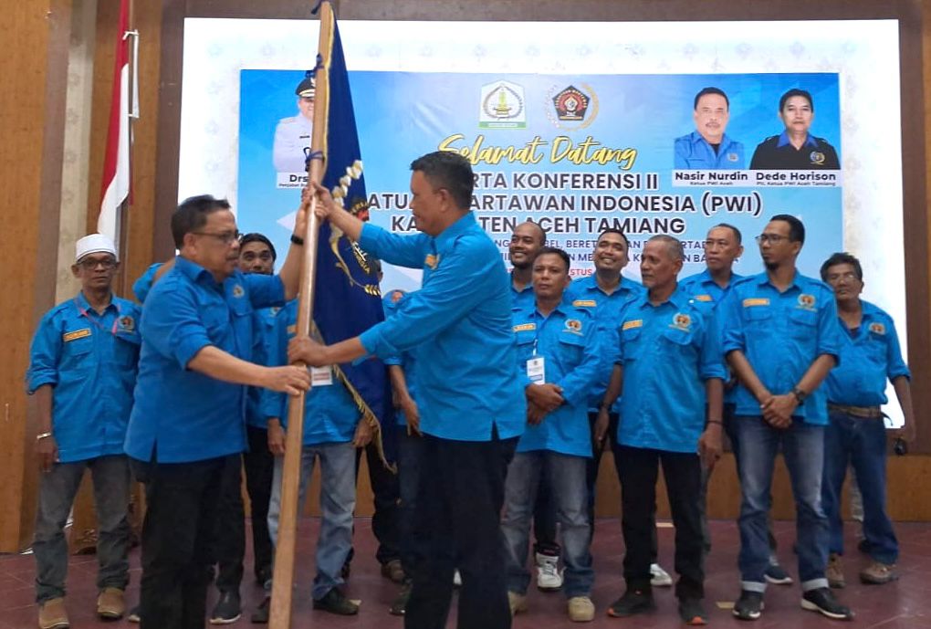 Ketua PWI Aceh Nasir Nurdin menyerahkan pataka organisasi PWI kepada Erwan yang terpilih Ketua PWI Aceh Tamiang periode 2024-2027 melalui Konferkab II di SKB Karang Baru, Selasa, 30 Juli 2024. (Foto: Dok. PWI Aceh)