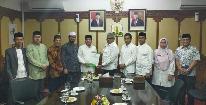 Ketua MPU Aceh Tgk H Faisal Ali menyerahkan Taushiyah MPU Aceh No. 5 Tahun 2024 tentang pelaksanaan PON XXI Aceh-Sumut kepada Pj Gubernur Aceh Bustami Hamzah di ruang kerjanya, Jum'at (5/7/2024). (Foto: For Infoaceh.net)