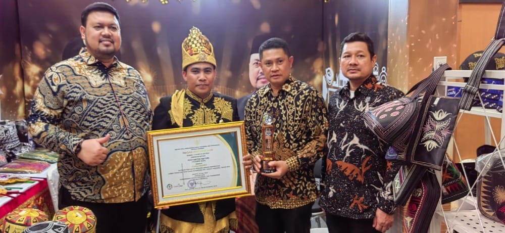 Ketua Posyantek Naturi Faisal didampingi Kepala DPMG Aceh T Aznal Zahri usai menerima piala Juara favorit nasional pada lomba Teknologi Tepat Guna Nasional (TTGN) ke-25 di Lapangan Islamic Center Mataram, Nusa Tenggara Barat (NTB), Senin (15/7/2024). Foto: Istimewa