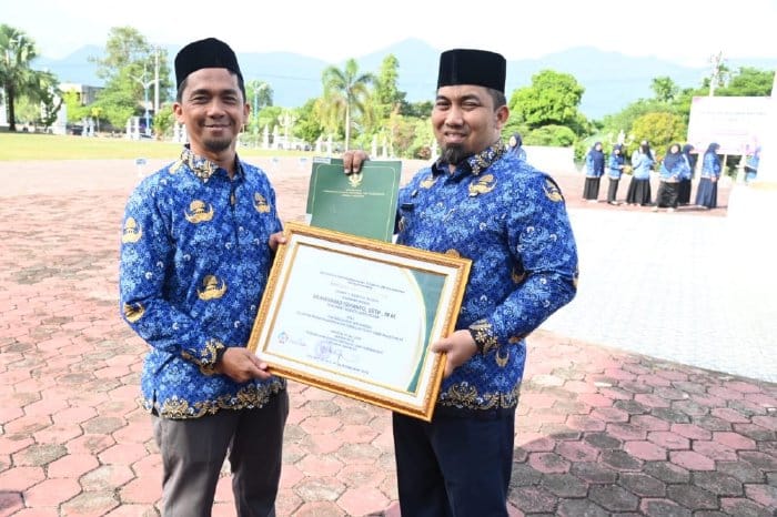Pj Bupati Aceh Besar Muhammad Iswanto menerima penghargaan dari Kemendes RI atas kepedulian terhadap Pengembangan Teknologi Tepat Guna yang diserahkan Kadis DPMG Aceh Besar Carbaini di halaman Kantor Bupati, Aceh Besar, Selasa (23/7). Foto: Istimewa