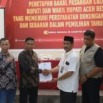 Ketua KIP Aceh Besar T Khairun Salim, menyerahkan berkas syarat dan ketentuan Pilkada Aceh Besar kepada Syukri A. Jalil pada penetapan bakal pasangan calon Bupati/Wakil Bupati Aceh Besar yang memenuhi syarat di Orion Hall Kecamatan Darul Imarah, Aceh Besar, Senin (19/8). Foto: For Infoaceh.net