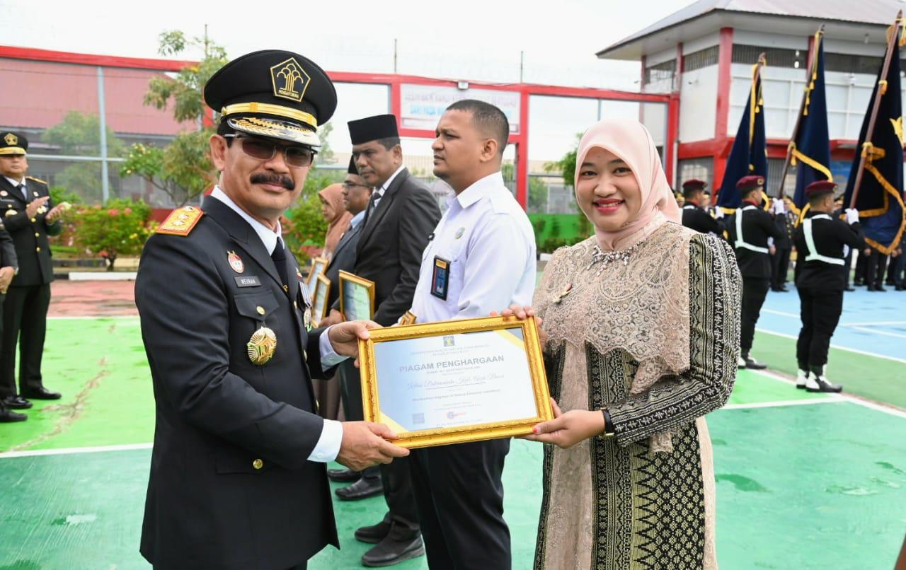 Pj Ketua Dekranasda Aceh Besar Cut Rezky Handayani menerima Piagam Penghargaan Bidang Kekayaan Intelektual dari Kakanwil Kemenkumham Aceh Meurah Budiman di Lapas Kelas IIA, Gampong Bineh Blang, Ingin Jaya, Aceh Besar, Senin (19/8/2024). (FOTO/MC ACEH BESAR)