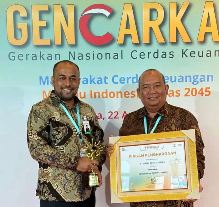 Plt. Direktur Utama Bank Aceh Fadhil Ilyas didampingi Direktur Kepatuhan Numairi saat menerima penghargaan "Financial Literacy Award 2024" dari OJK, Kamis (22/8). (Foto: For Infoaceh.net)