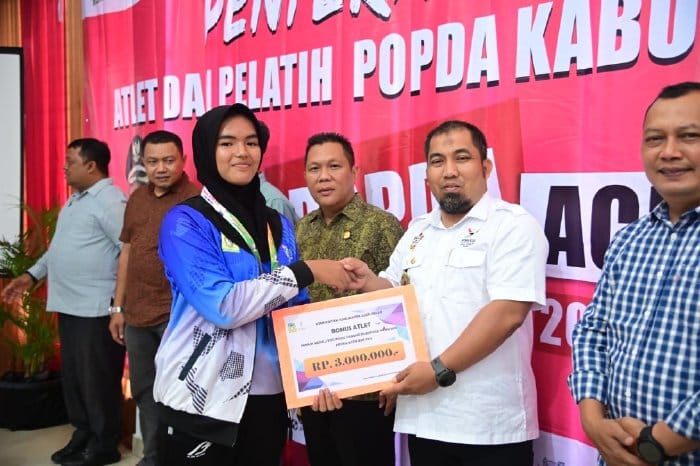 Pj Bupati Aceh Besar Muhammad Iswanto menyerahkan bonus untuk atlet dan pelatih Popda XVII Provinsi Aceh di Aceh Timur 2024, dalam acara di Gedung Dekranasda, Gampong Gani, Kecamatan Ingin Jaya, Jum'at sore (6/9/2024). (Foto For Infoaceh.net)