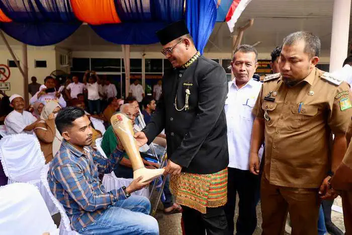 Pj Gubernur Aceh Safrizal ZA didampingi Pj Bupati Aceh Besar Muhammad Iswanto menyerahkan bantuan kaki palsu untuk masyarakat di Kantor Administrasi Bandara SIM PT Angkasa Pura II, Kecamatan Blang Bintang, Selasa (3/9/2024). (FOTO: MC ACEH BESAR)