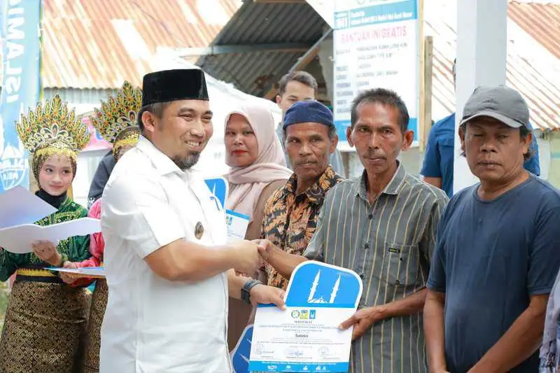 Pj Bupati Aceh Besar, Muhammad Iswanto menyerahkan kunci rumah dhuafa berstruktur tahan gempa tipe 36 secara simbolis kepada penerima manfaat di Gampong Geundrieng, Kecamatan Darul Imarah, Aceh, Ahad (2/2/2025)