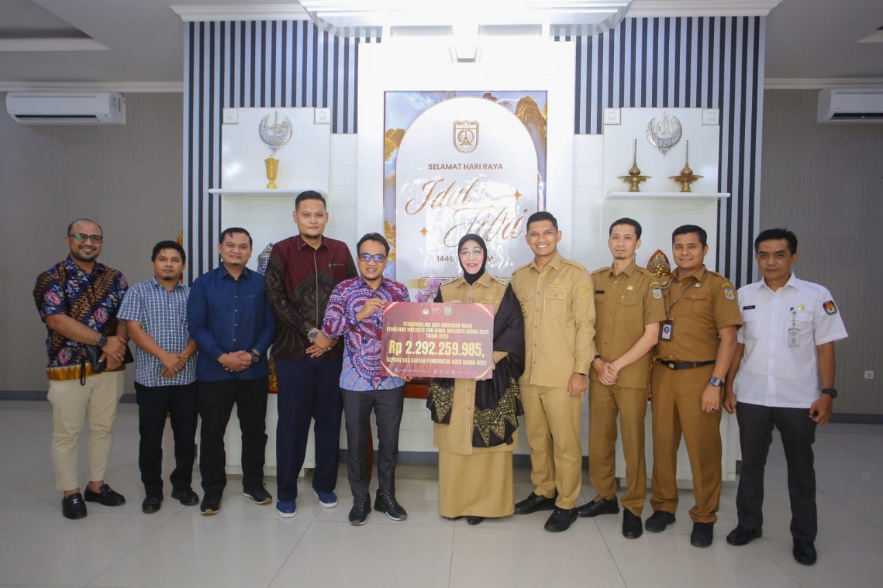 Ketua KIP Banda Aceh Yusri Razali mengembalikan sisa dana hibah Pilkada 2024 kepada Wali Kota Banda Aceh Illiza Sa’aduddin Djamal di pendopo, Senin (21/4). (Foto: Humas Pemko Banda Aceh)