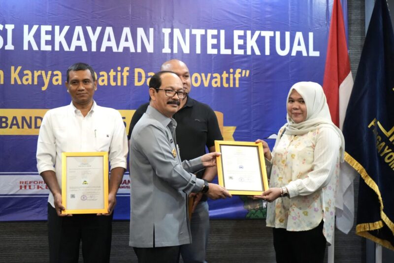 Kakanwil Kemenkum Aceh Meurah Budiman menyerahkan sertifikat merek kepada pelaku usaha di Aceh pada Selasa (6/5) di Hotel Kyriad Muraya, Banda Aceh