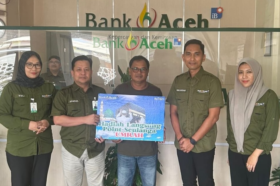 Pemimpin Bank Aceh Cabang Idi Rayeuk, Samsul Bahri didampingi Pimpinan Capem Julok Iskandar menyerahkan hadiah umrah kepada nasabah. (Foto: Ist)
