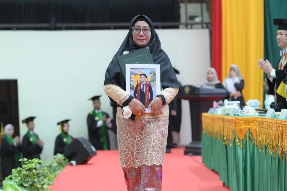 Fitri Ermawati, ibu dari almarhum Jodi Ramadhansyah menerima ijazah pada wisuda Angkatan ke-165 USK di Gedung AAC Dayan Dawood, Rabu (28/5/2025). (Foto: Dok. USK Banda Aceh)