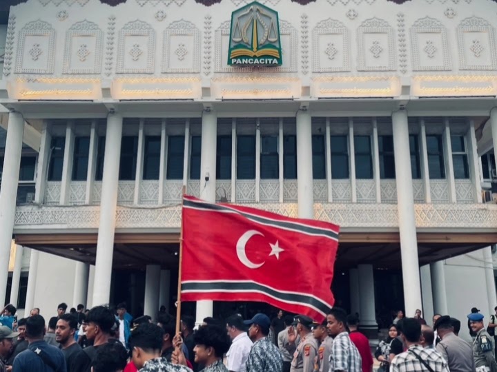 Bendera Bulan Bintang dikibarkan dalam aksi demonstrasi yang digelar di halaman Kantor Gubernur Aceh, pada Senin (16/06/2025). (Foto: Instagram / @rajihul.23)