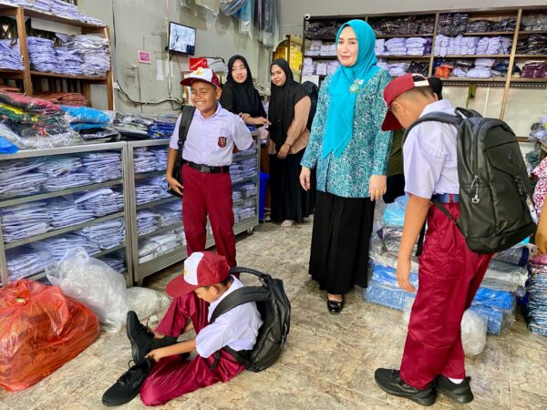 Marlina Usman, Bunda PAUD Aceh, membantu memilihkan sepatu dan seragam baru untuk 3 siswa SD di Blangpidie, Selasa (17/6). Aksi spontan ini dilakukan setelah ia melihat sepatu lusuh yang mereka kenakan. (Foto: For Infoaceh.net)