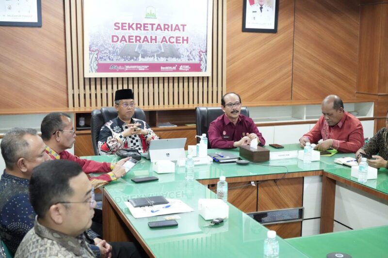 Kakanwil Kemenkumham Aceh Meurah Budiman, menyampaikan laporan capaian pengesahan badan hukum Koperasi Merah Putih Desa/Kelurahan dalam rapat evaluasi di Ruang Setda Aceh, Kamis (26/6/2025). (Foto: Ist)
