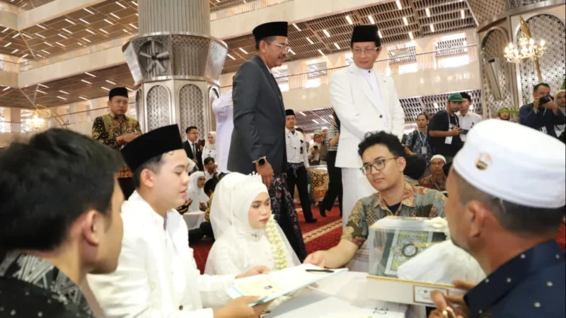 Infoaceh.net – Sebanyak 100 pasangan mengikuti prosesi nikah massal yang digelar di Masjid Istiqlal, Jakarta, Sabtu (28/6/2025). Acara ini menjadi bagian dari peringatan Tahun Baru Islam 1 Muharram 1447 Hijriah yang diselenggarakan oleh Kementerian Agama RI. Pantauan di lokasi, ratusan mempelai pria dan wanita tampak khidmat mengenakan busana adat dan pakaian muslim formal. Mereka duduk berdampingan di atas karpet merah masjid, didampingi wali serta keluarga masing-masing. Di depan mereka tertata kotak mahar dan dokumen nikah yang menjadi simbol keabsahan prosesi akad. Akad nikah berlangsung bergantian di bawah pengawasan para penghulu dari Kantor Urusan Agama (KUA). Prosesi berjalan tertib dan penuh haru. Menteri Agama Nasaruddin Umar yang hadir langsung menyampaikan apresiasinya terhadap antusiasme para peserta. Ia menyebut nikah massal ini bukan sekadar peristiwa administratif, melainkan momentum spiritual yang membawa berkah. “Insyaallah ini momen penuh berkah. Fasilitas sudah kami siapkan, termasuk kamar hotel untuk semua pasangan. Malam ini, silakan menikmati malam halal,” ujar Nasaruddin yang disambut gelak tawa para hadirin. Tak hanya akomodasi, beberapa pasangan juga mendapatkan bantuan modal usaha dari mitra penyelenggara. Nasaruddin berharap pernikahan massal ini menjadi awal kehidupan yang sakinah, baik di dunia maupun akhirat. “Pernikahan bukan hanya tanggung jawab duniawi, tapi juga hingga akhirat. Ibu-ibu, jangan takut disaingi bidadari surga, karena ibu-ibu yang salehah akan lebih cantik dari bidadari,” tambahnya dengan senyum. Program nikah massal ini ditujukan bagi masyarakat kurang mampu yang terkendala biaya. Pendaftaran dilakukan melalui KUA masing-masing hingga 20 Juni 2025. Seluruh fasilitas diberikan secara gratis, termasuk bimbingan perkawinan (Bimwin), buku nikah, serta suvenir resmi dari panitia. Direktur Jenderal Bimbingan Masyarakat Islam Kemenag, Abu Rokhmad, menegaskan bahwa program ini bertujuan memberikan legalitas pernikahan baik secara agama maupun negara. “Kami ingin membuka akses pernikahan yang sah tanpa beban biaya, agar masyarakat bisa melangsungkan kehidupan rumah tangga dengan tenang dan resmi,” ujarnya. Suasana hangat, tawa haru, dan rasa syukur mewarnai seluruh rangkaian acara, menjadikan nikah massal ini sebagai salah satu peringatan Tahun Baru Islam yang paling membekas di hati para peserta dan keluarga.
