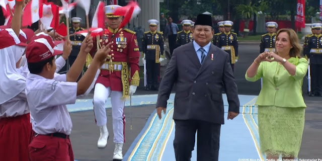 Presiden Peru Dina Boluarte membentuk tanda hati kepada siswa saat upacara penyambutan di Istana Merdeka, Jakarta.