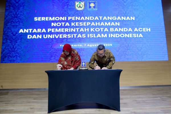 Wali Kota Banda Aceh, Illiza Sa’aduddin Djamal (kanan), dan Rektor UII Yogyakarta, Fathul Wahid (kiri), saat menandatangani nota kesepahaman (MoU) kerja sama di Gedung Kuliah Umum Dr. Sardjito UII, Kamis (7/8/2025).