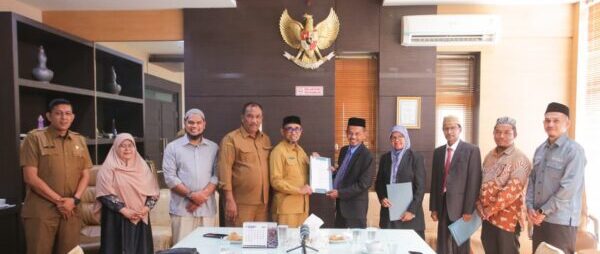 Pj Sekda Banda Aceh, Jalaluddin, menyerahkan SK Wali Kota kepada Dewan Pengawas Baitul Mal Banda Aceh, Selasa (12/8/2025).