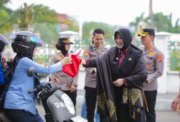 Wali Kota Banda Aceh Illiza Sa’aduddin Djamal bersama Forkopimda membagikan bendera merah putih kepada warga di depan Masjid Raya Baiturrahman, Senin (11/8/2025)