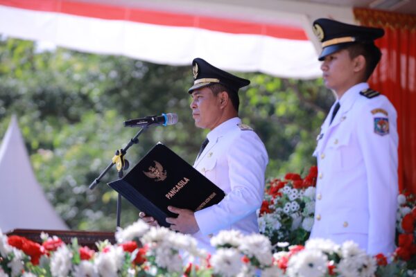 Bupati Aceh Besar Muharram Idris atau Syech Muharram menyerahkan bendera pusaka kepada Paskibraka pada upacara peringatan HUT ke-80 Kemerdekaan RI di Lapangan Bungoeng Jeumpa, Kota Jantho, Ahad (17/8). (Foto: Ist)