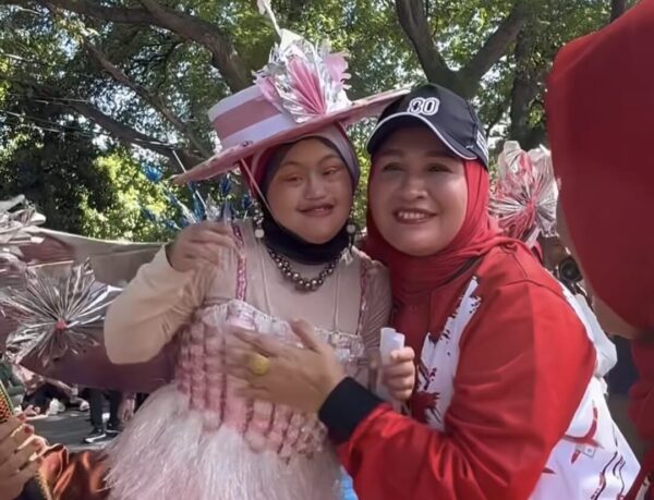 Ketua TP PKK Aceh Marlina Usman memeluk Sykira, saat siswa SLB CD YPAC Banda Aceh itu melintasi panggung kehormatan Pawai Budaya HUT ke-80 RI, di depan Meuligoe Gubernur Aceh, Senin (18/8). (Foto: Ist)