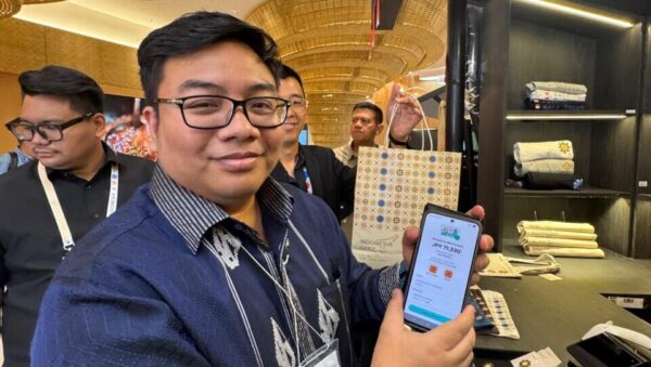 Anggota Komisi VI DPR RI, Kawendra Lukistian, saat mencoba langsung pembayaran menggunakan QRIS di Indonesia Pavilion pada Osaka Expo, Jepang, Kamis (21/8/2025).