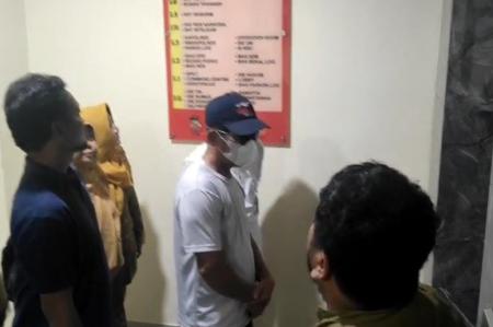 Guru SMPN 13 Kota Bekasi berinisial JP saat digiring petugas kepolisian untuk menjalani pemeriksaan di Polres Metro Bekasi Kota atas dugaan pelecehan seksual, Rabu (27/8/2025).
