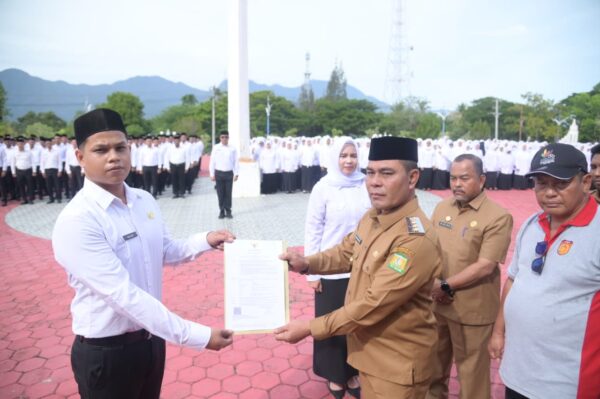 Bupati Aceh Besar Muharram Idris menyerahkan SK pengangkatan kepada perwakilan PPPK di halaman Kantor Bupati Aceh Besar, Jantho, Senin (8/9). (Foto: Ist)