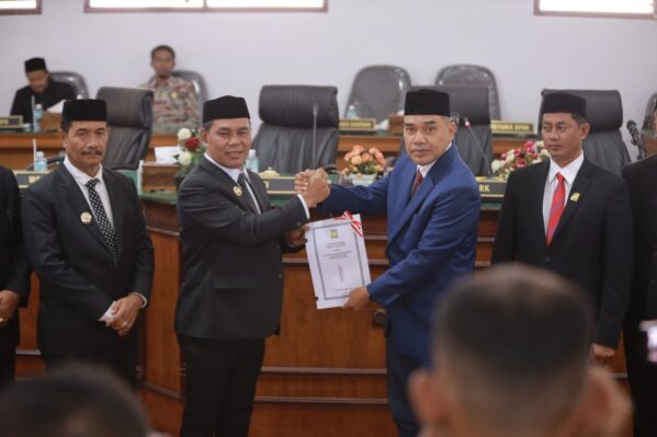 Bupati Aceh Besar Muharram Idris menyerahkan rancangan qanun perubahan APBK Aceh Besar tahun 2025 pada rapat paripurna DPRK Aceh Besar di Gedung DPRK setempat, Rabu (25/9).