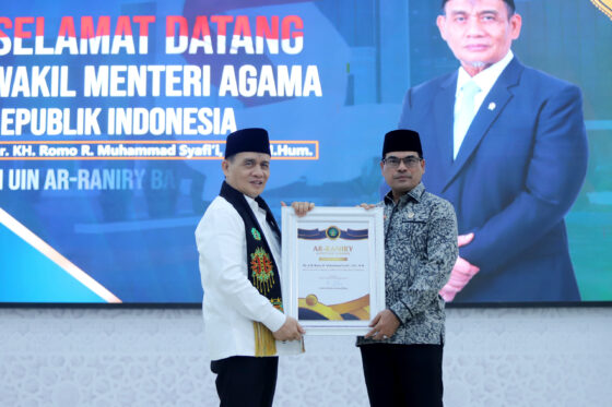 Rektor UIN Ar-Raniry Prof Mujiburrahman menyerahkan Ar-Raniry Lifetime Award kepada Wakil Menteri Agama Dr KH Romo R. Muhammad Syafi'i SH MHum dalam kuliah di kampus tersebut, Jum'at (26/9). (Foto: Ist)