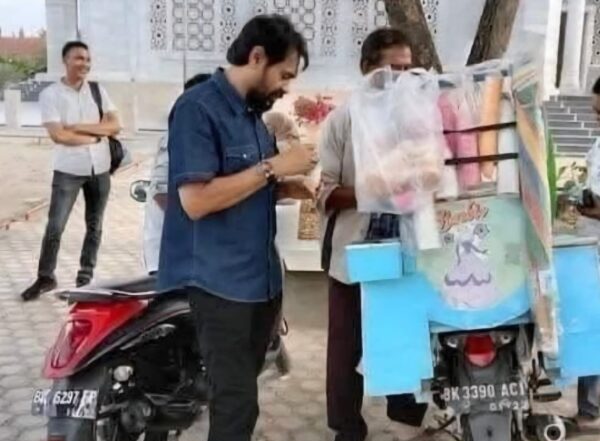 Gubernur Aceh Muzakir Manaf atau Mualem saat jajan es krim di depan sebuah masjid di Aceh yang penjualnya menggunakan sepeda motor berplat BK. (Foto: Ist)