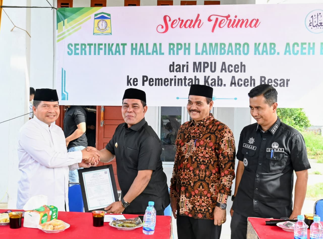 Ketua MPU Aceh Tgk H Faisal Ali menyerahkan sertifikat halal Rumah Potong Hewan Lambaro, Ingin Jaya, Aceh Besar kepada Bupati Aceh Besar Muharram Idris, Jum'at (31/10). (Foto: Ist)