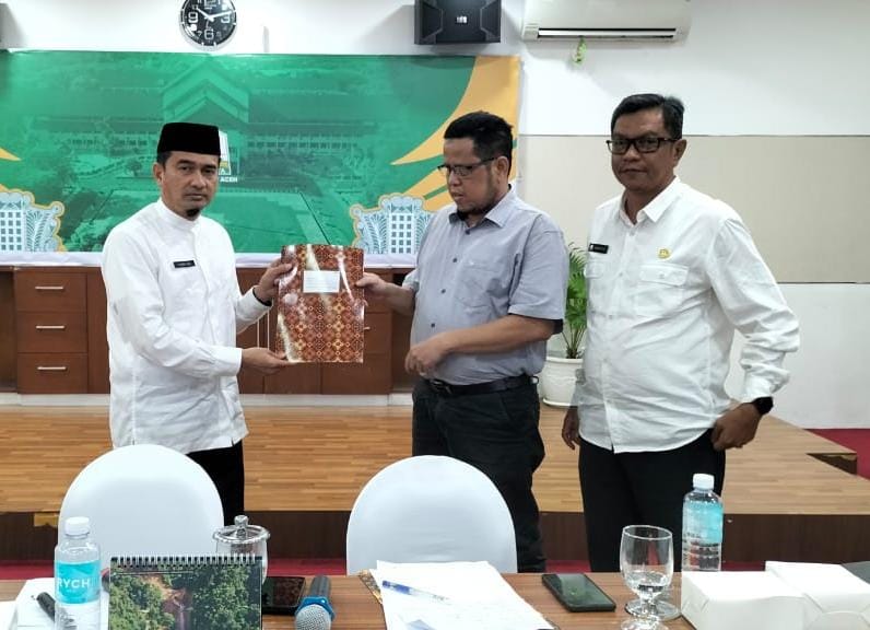 Ketua Perkumpulan Penyandang Disabilitas Indonesia (DPD PPDI) Aceh, Hamdanil, menyerahkan resume bahan pertimbangan kepada Kepala Biro Isra Setda Yusrizal pada rapat pembentukan Tim Penyusunan Pergub Turunan Qanun Disabilitas, Rabu (22/10) di kantor Gubernur Aceh. (Foto: Dok DPD PPDI Aceh)