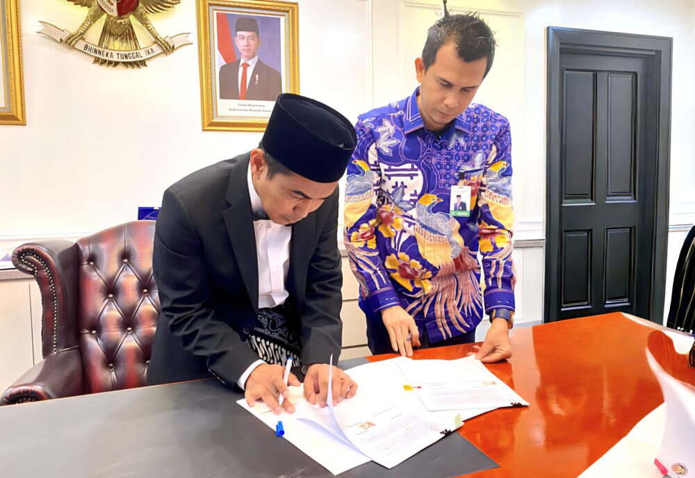Plt. Dirjen Pengembangan Ekosistem Haji dan Umrah Prof Jaenal Effendi SAg MA dan Direktur Dana dan Jasa Bank Aceh, M Hendra Supardi menandatangani kerja sama. (Foto: Ist)