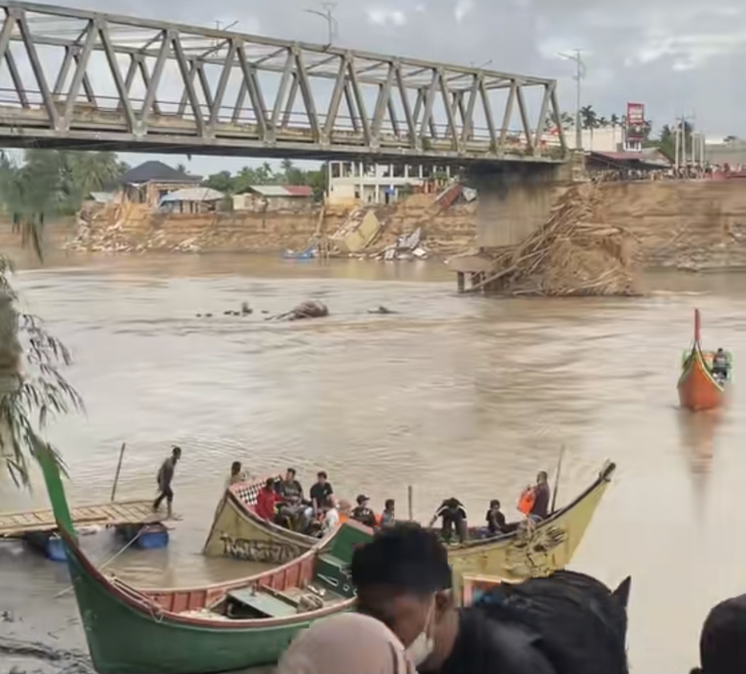 Penyeberangan menggunakan boat di jembatan putus kawasan Kutablang, Bireuen. (Foto: Ist)