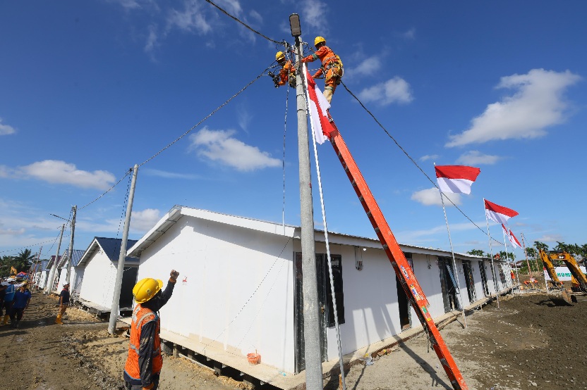 Petugas PLN menyambung jaringan listrik di Rumah Hunian Sementara Aceh Tamiang. PLN telah menyiapkan infrastruktur kelistrikan di kawasan tersebut, seperti pembangunan trafo, jaringan listrik dan kWh meter untuk masing-masing rumah yang telah terbangun. (Foto: Ist)